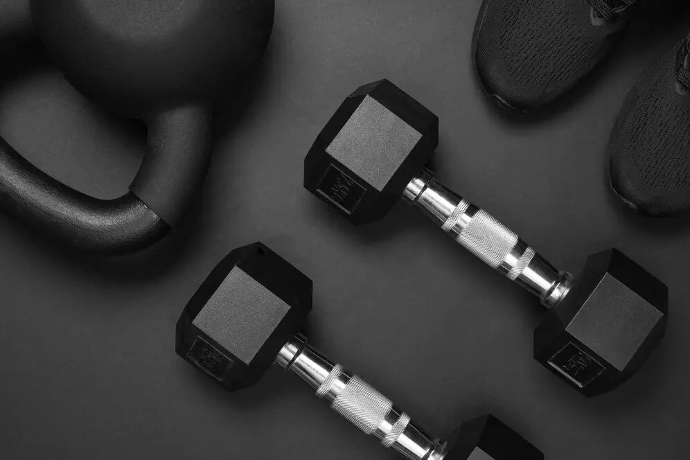 Dumbbell & Barbell hitam yang digunakan sebagai alat kebugaran