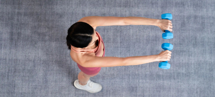seorang wanita sedang melakukan latihan dengan dumbbell untuk menjawab kardio dulu atau angkat beban dulu.webp