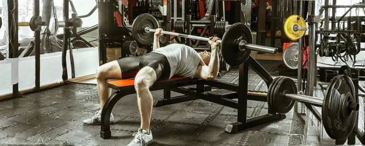 seorang pria sedang melatih otot dadanya dengan alat bench press terbaik yang ada di gym