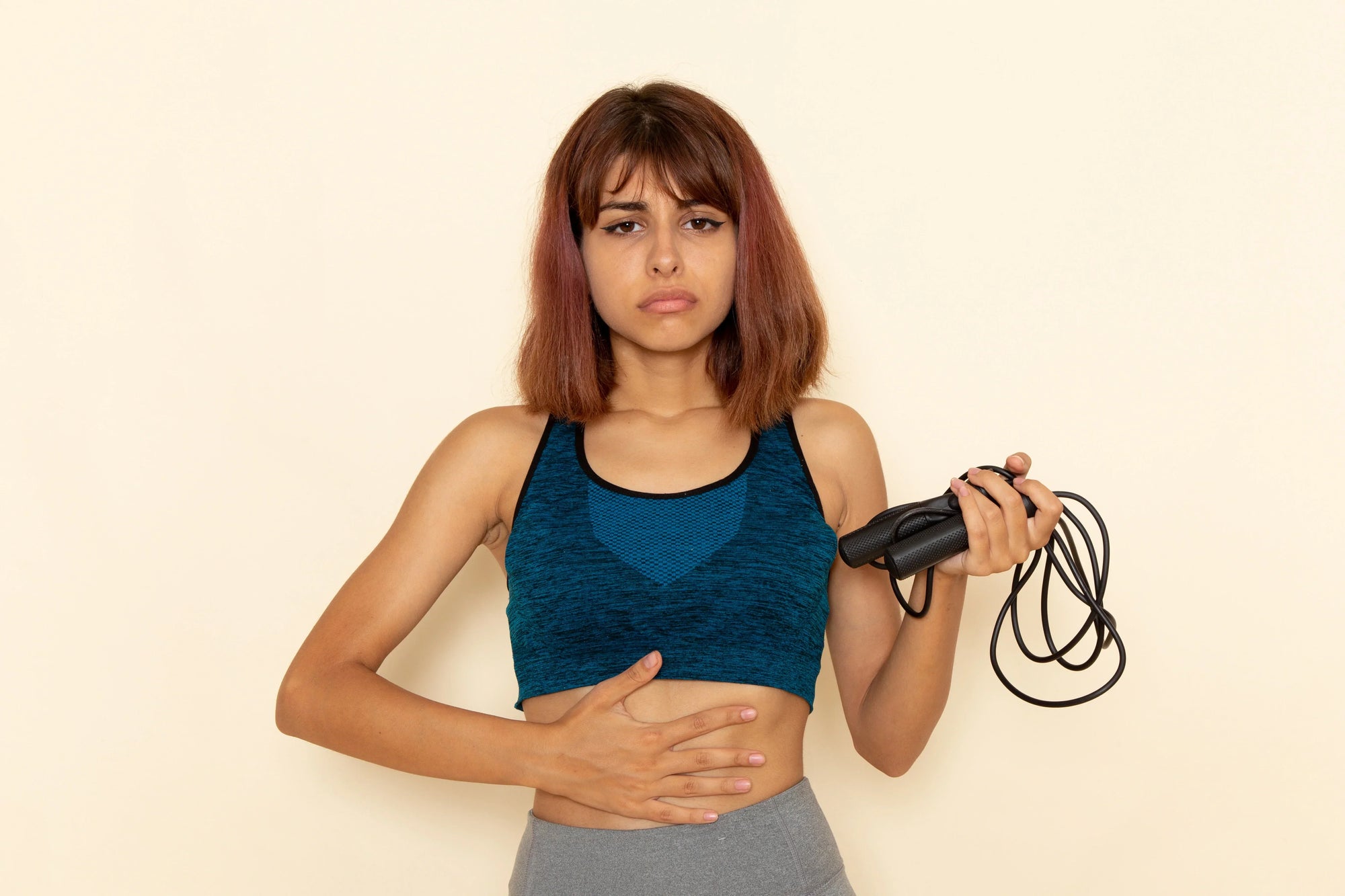 seorang wanita menggunakan skipping rope sebagai alat olahraga untuk mengecilkan perut buncit