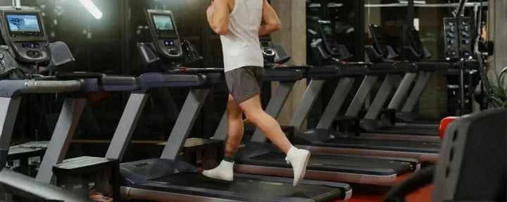Seorang pria sedang berlari di atas alat treadmill terbaik di pusat kebugaran modern yang dilengkapi fitur digital canggih untuk latihan maksimal