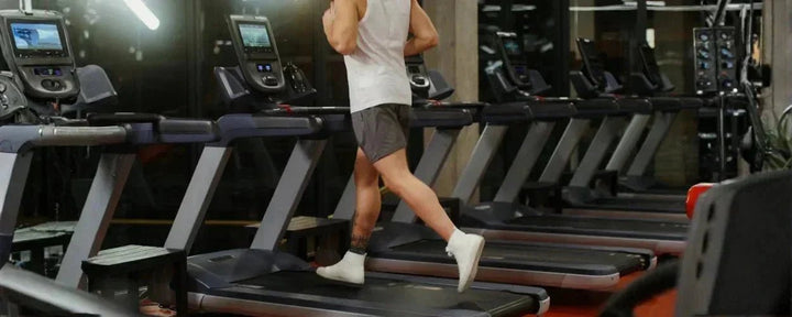Seorang pria sedang berlari di atas alat treadmill terbaik di pusat kebugaran modern yang dilengkapi fitur digital canggih untuk latihan maksimal
