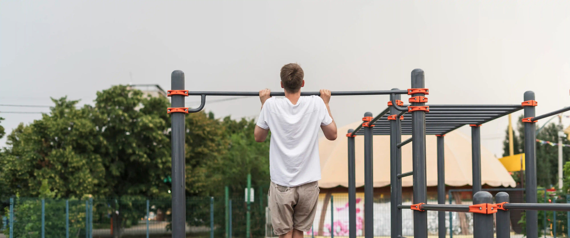 seseorang melakukan pull-up di area outdoor sebagai contoh praktik latihan apa itu kalistenik yang memanfaatkan berat badan sendiri untuk membangun kekuatan