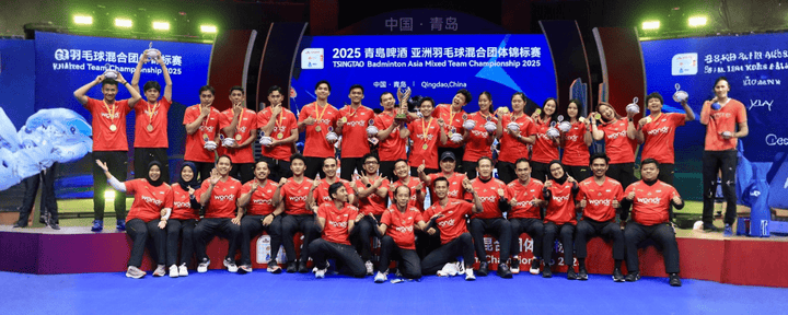 Para atlet bulu tangkis Indonesia berpose bersama di panggung pertandingan sambil mengenakan medali dan seragam merah dengan ekspresi penuh kebanggaan (sumber: pbsi.id)