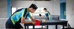Seorang pemain sedang bersiap melakukan backhand tenis meja dengan fokus pada teknik pukulan yang tepat