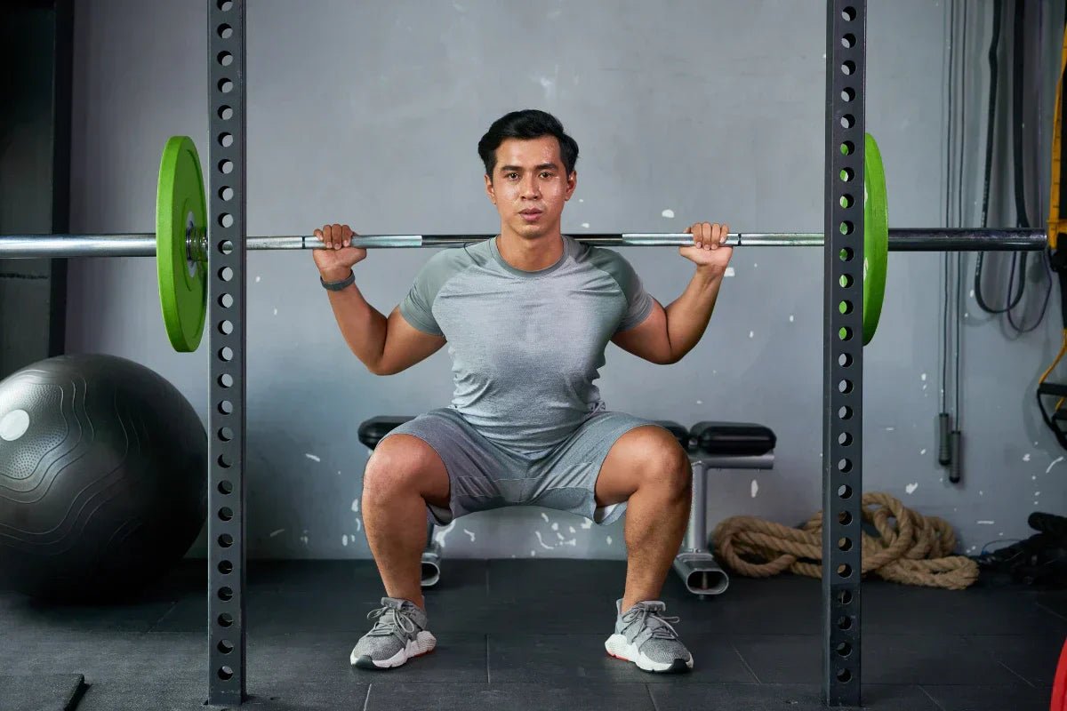 Seorang pria yang sedang squat dengan barbel