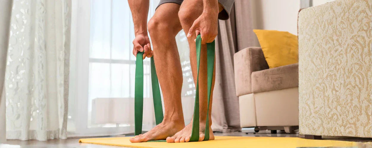 seseorang yang sedang bersiap melakukan calf raises menggunakan resistance band, sebuah latihan sederhana untuk menguatkan otot betis dan meningkatkan stabilitas kaki