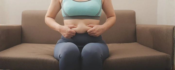 seorang wanita memegang perutnya sembari memikirkan cara mengecilkan perut buncit untuk wanita dengan cepat agar tampil percaya diri kembali