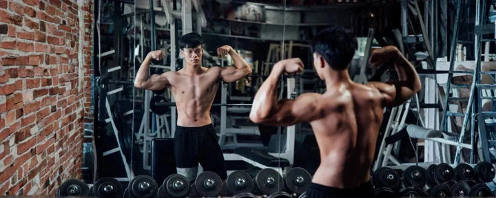Seorang pria sedang berpose di depan cermin gym.