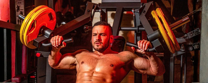 Seorang pria sedang melakukan latihan chest press adalah gerakan push fundamental menggunakan mesin gym untuk melatih otot dada, bahu depan, dan triceps secara optimal.
