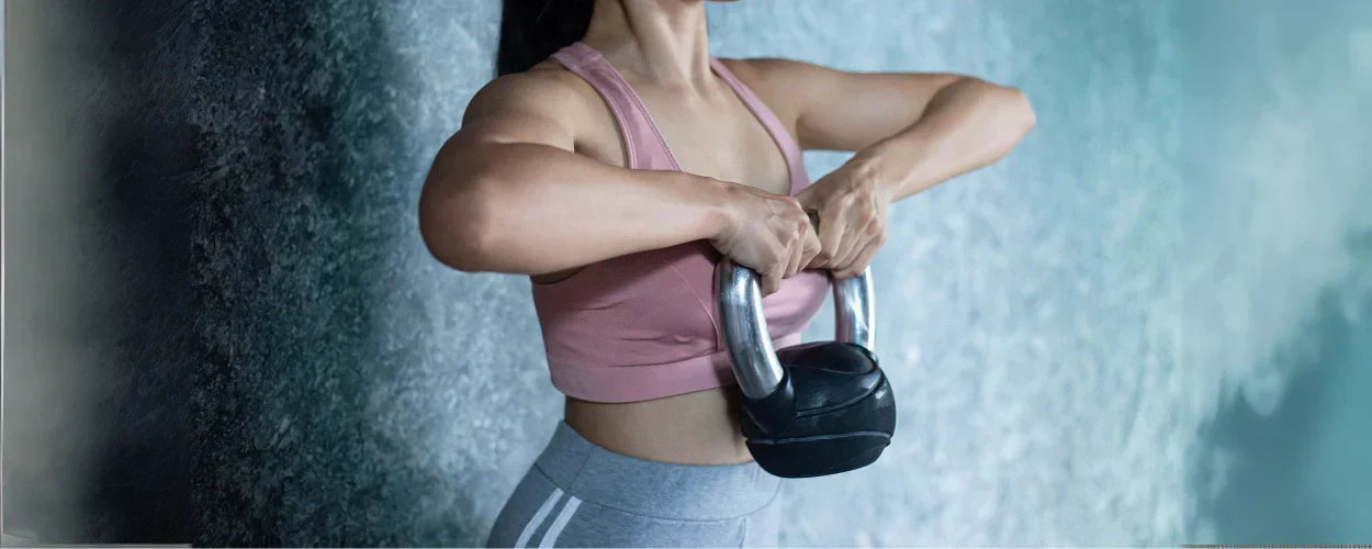 seseorang sedang berlatih menggunakan kettlebell, menggambarkan bahwa free weight adalah latihan beban bebas yang melatih kekuatan dan stabilitas tubuh secara alami