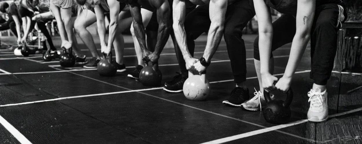 Para peserta sedang melakukan latihan dengan kettlebell sebagai bagian dari Hyrox workout, yakni kombinasi lari dan functional training yang menguji kekuatan serta daya tahan tubuh