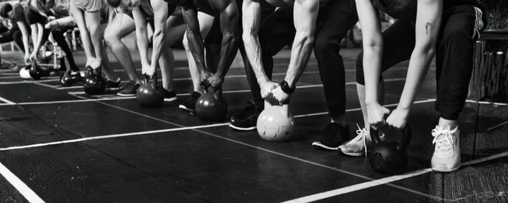 Para peserta sedang melakukan latihan dengan kettlebell sebagai bagian dari Hyrox workout, yakni kombinasi lari dan functional training yang menguji kekuatan serta daya tahan tubuh