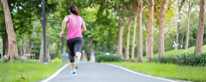 seorang wanita yang sedang berlari di taman, menggambarkan rutinitas olahraga untuk menjawab pertanyaan lari seminggu berapa kali