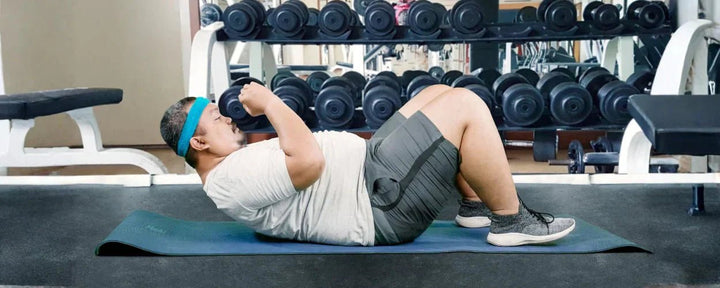 seorang pria gemuk sedang mempraktikan gerakan latihan abs untuk pemula