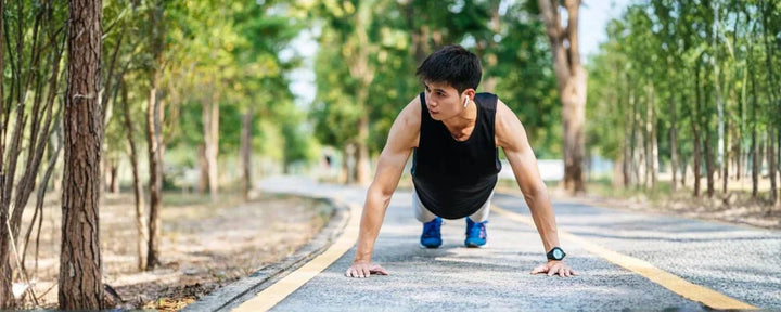 Seorang pria melakukan push up di area outdoor sebagai bentuk latihan daya tahan untuk meningkatkan kekuatan dan kebugaran tubuh