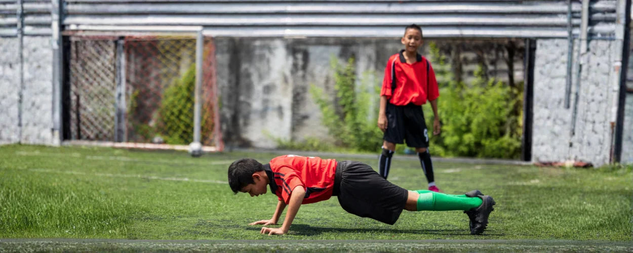 anak-anak yang sedang melakukan latihan fisik sepakbola untuk meningkatkan kekuatan dan ketahanan tubuh di lapangan