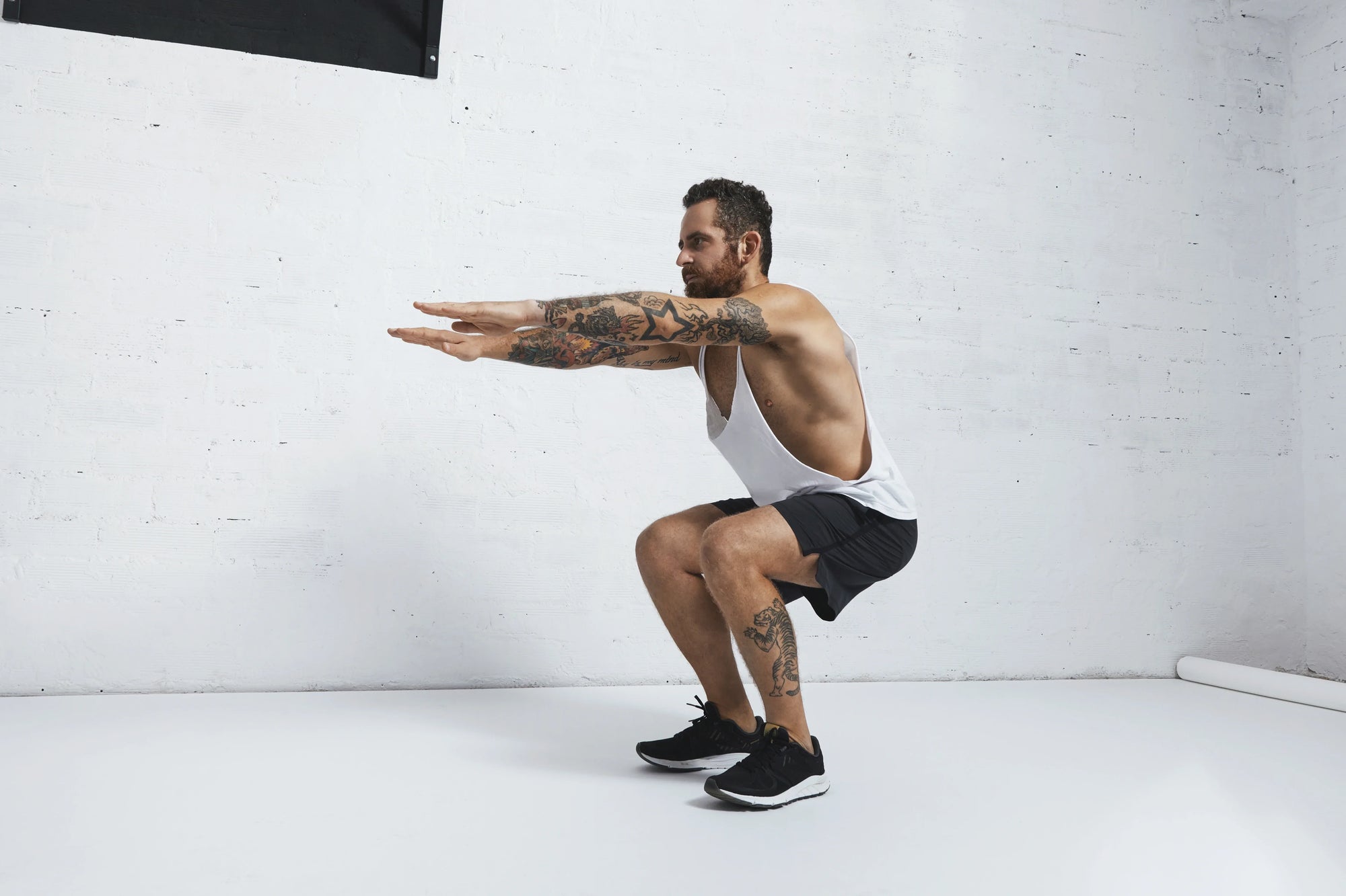 seorang pria yang sedang melakukan squat, sebuah latihan yang melibatkan macam macam seperti air squat, goblet squat, dan sumo squat