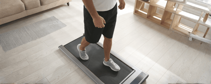 seseorang yang sedang berjalan di atas walking pad, menggambarkan manfaat jalan di walking pad untuk menjaga kebugaran dan meningkatkan kesehatan jantung secara praktis di rumah
