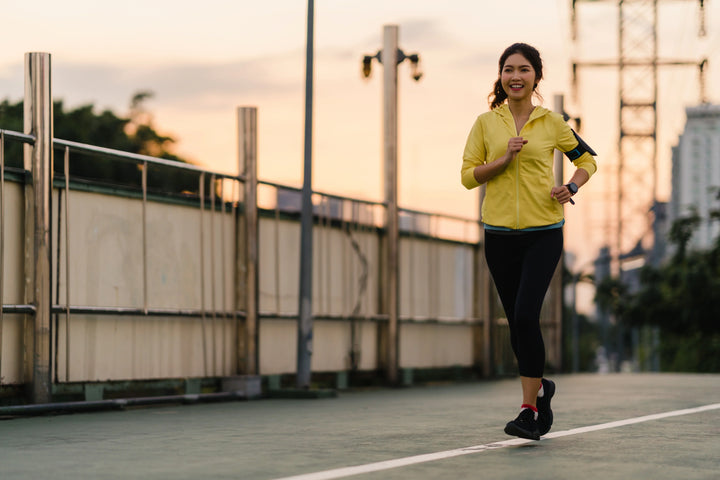 Seorang wanita berolahraga dengan penuh semangat di pagi hari, menggambarkan manfaat lari pagi yang dapat meningkatkan energi, kesehatan, dan mood positif