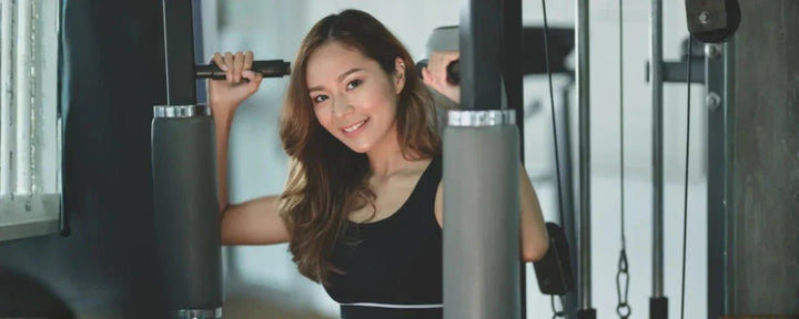 seorang wanita yang berlatih di gym dengan alat fitness, menggambarkan manfaat ngegym bagi wanita untuk meningkatkan kekuatan tubuh, kebugaran, dan rasa percaya diri