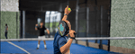 Seorang pemain sedang melakukan servis padel, menggambarkan manfaat olahraga padel dalam melatih fokus, koordinasi, dan kebugaran tubuh.