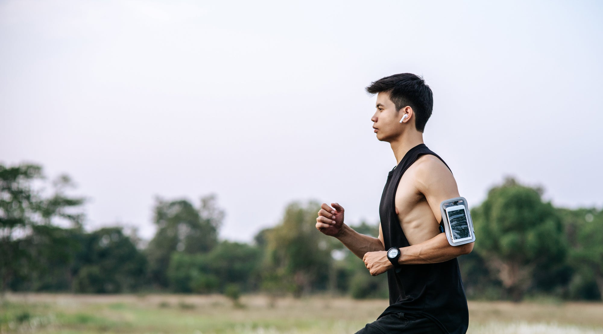 seorang pria berpakaian berwarna hitam sedang belari dengan speed pelan di outdoor