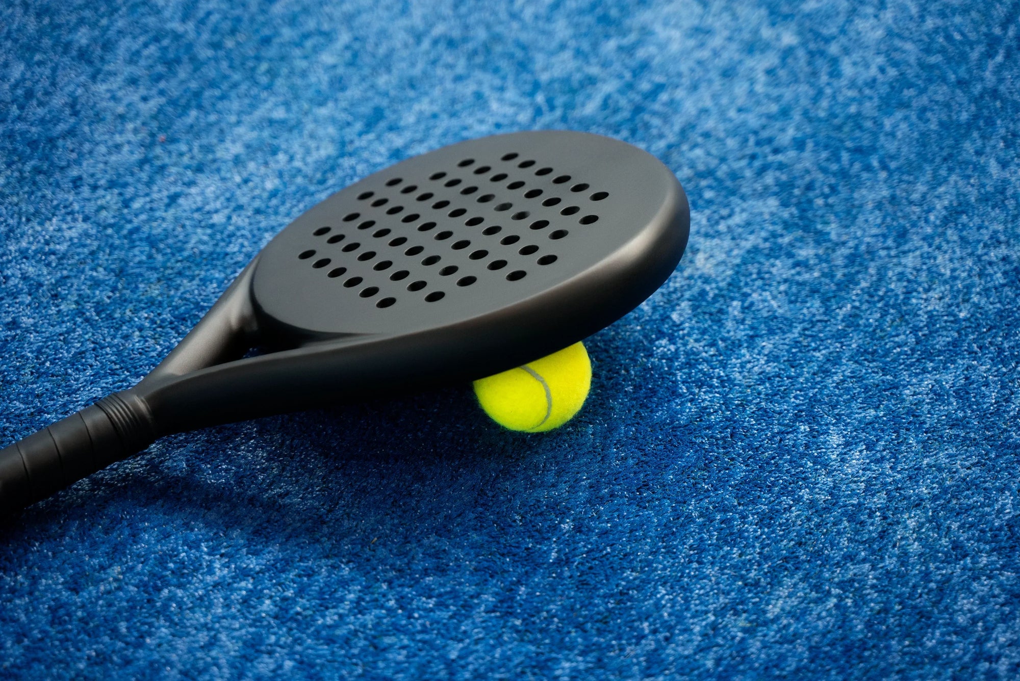 padel racket berwarna hitam dengan bolanya