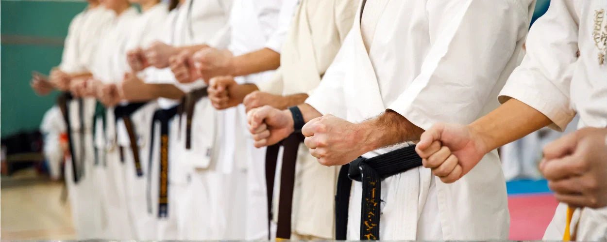 sekelompok atlet bela diri yang sedang bersiap berlatih, menggambarkan inti dari perbedaan karate dan taekwondo dalam teknik dan disiplin gerak mereka
