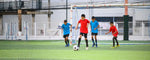 permainan mini soccer yang dilakukan oleh 4 anak laki-laki dari 2 tim yang berbeda