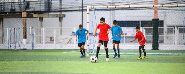 permainan mini soccer yang dilakukan oleh 4 anak laki-laki dari 2 tim yang berbeda