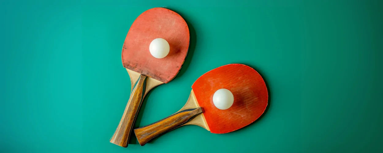 Dua bet dan bola di atas meja hijau menggambarkan awal mula perkembangan olahraga ini, yang menjadi bagian penting dalam sejarah tenis meja di dunia