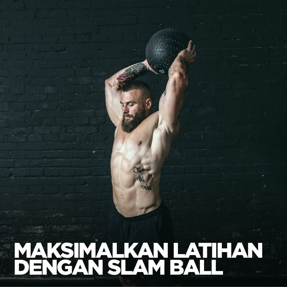 Pria berotot sedang mengangkat slam ball di atas kepala dalam ruangan gym dengan latar belakang dinding bata hitam.