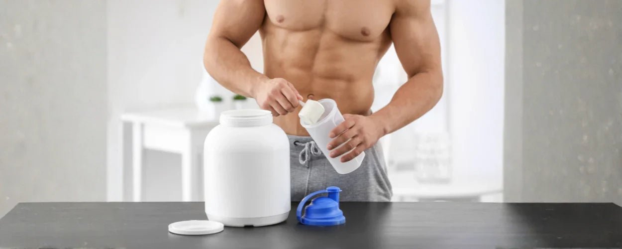 Seorang pria sedang menuang bubuk ke dalam shaker sebagai ilustrasi pilihan susu untuk bulking