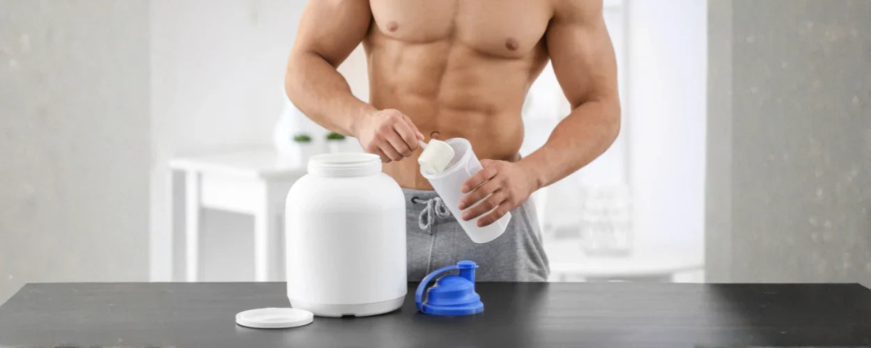 Seorang pria sedang menuang bubuk ke dalam shaker sebagai ilustrasi pilihan susu untuk bulking