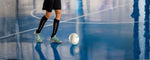 pemain yang sedang mengontrol bola di lapangan indoor, menggambarkan fokus dan ketepatan dalam menerapkan teknik dasar futsal