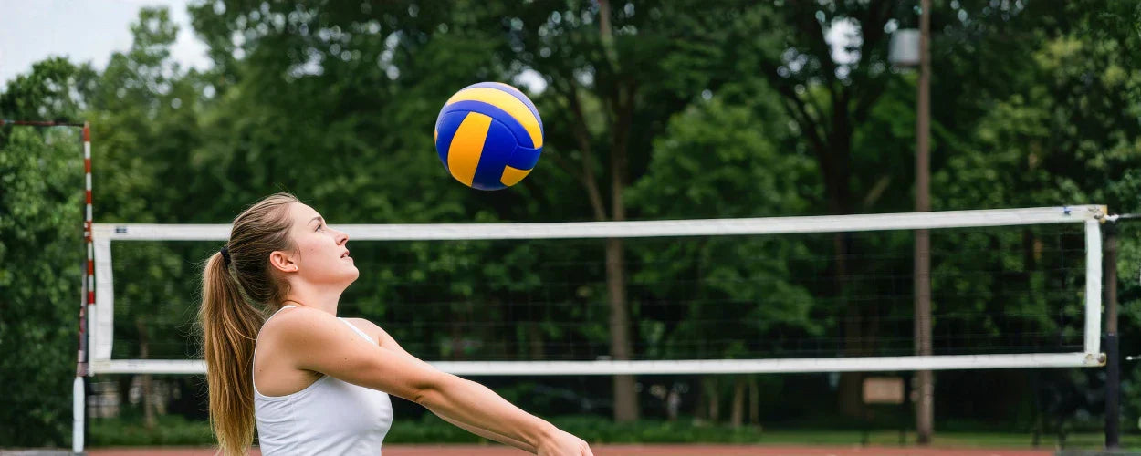 pemain yang mempraktikkan teknik dasar passing bola voli dengan melakukan passing bawah di lapangan luar ruangan.