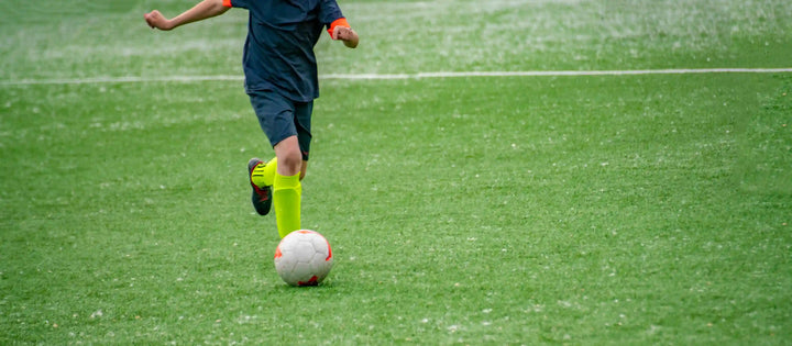 seorang atlet sedang mempraktikkan teknik dribbling sepak bola di stadion 