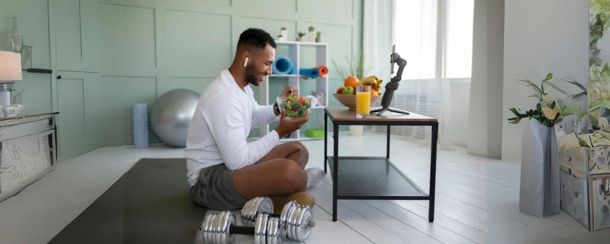 Seorang pria sedang menikmati salad sehat setelah berolahraga di rumah, menjadi ilustrasi nyata dari tips diet pemula yang mudah dan praktis dijalani sehari-hari