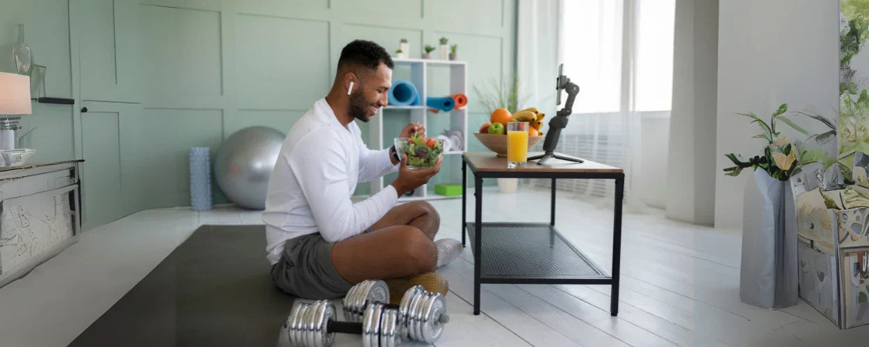 Seorang pria sedang menikmati salad sehat setelah berolahraga di rumah, menjadi ilustrasi nyata dari tips diet pemula yang mudah dan praktis dijalani sehari-hari