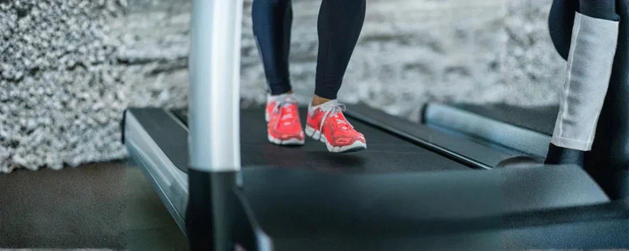 seseorang berjalan di atas alat treadmill ramping, menggambarkan bahwa walking pad adalah perangkat fitness praktis untuk berjalan di dalam ruangan guna menjaga kebugaran tubuh